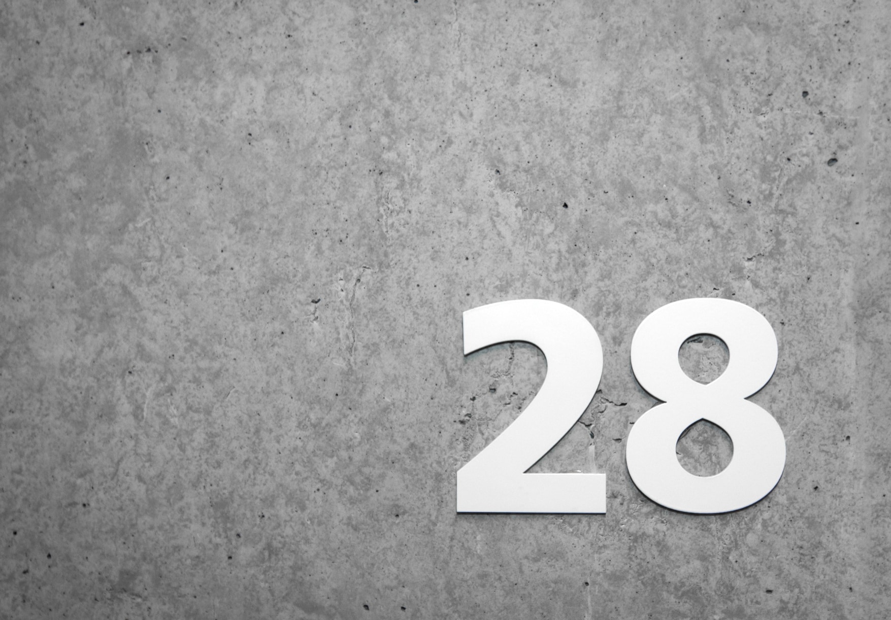 numéro d'étage 28 en littera blanc sur mur en beton lissé