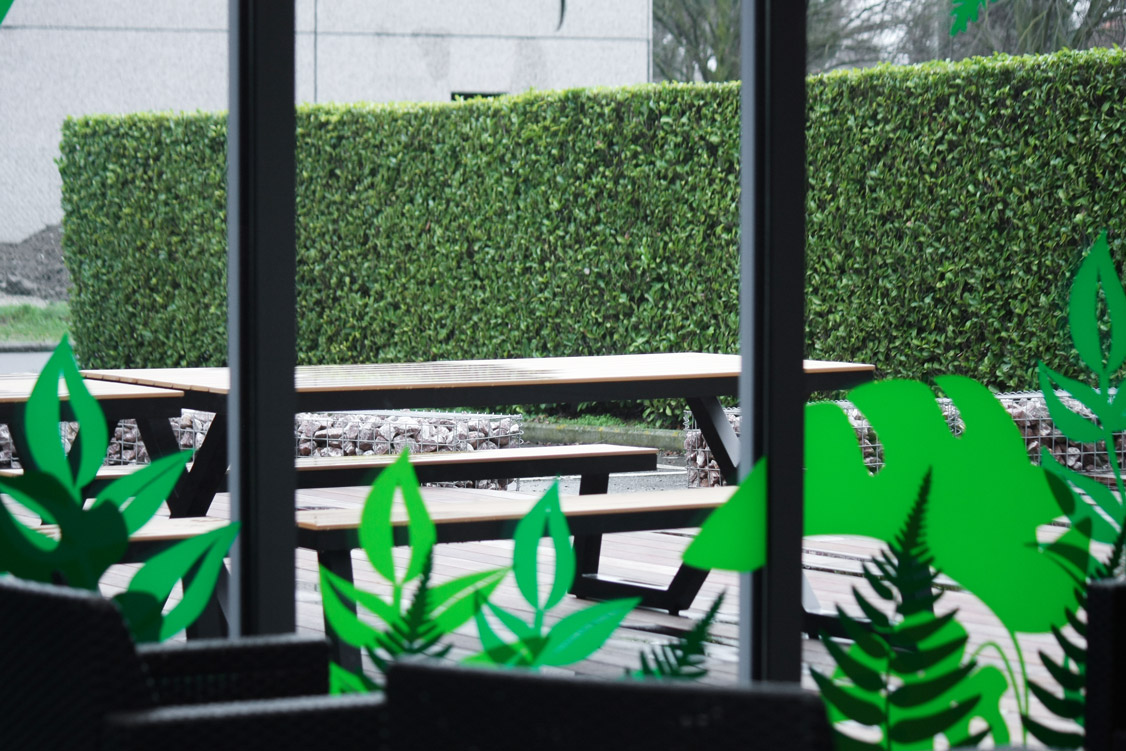 banc sur terrasse avec stickers verts sur vitre