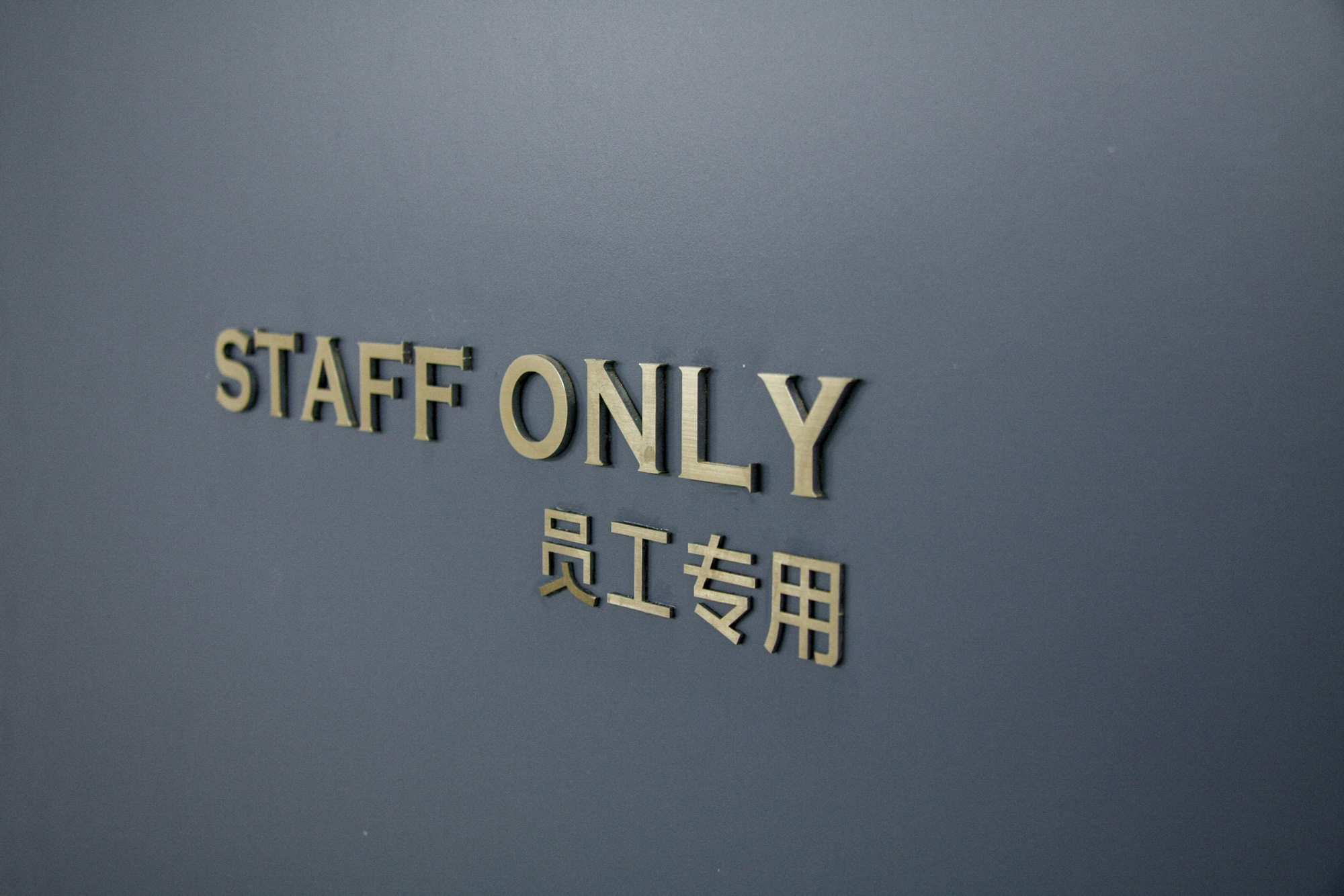 lettres sur porte indiquant staff onlu en cuivre
