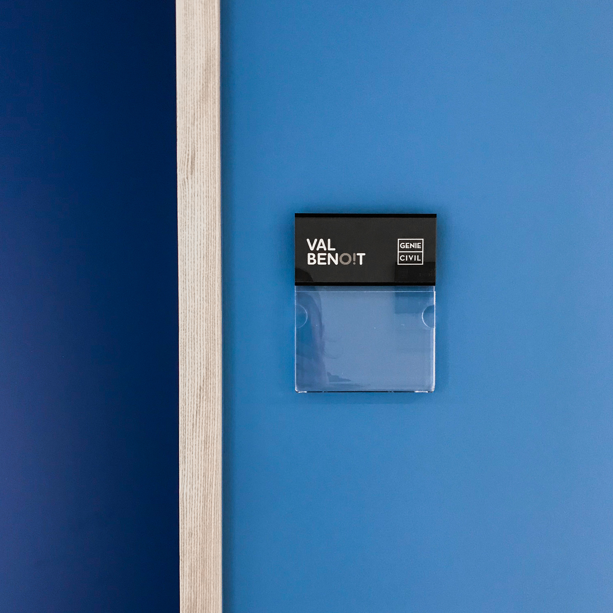 close up sur plaque de porte skwizmi sur mur coloré bleu