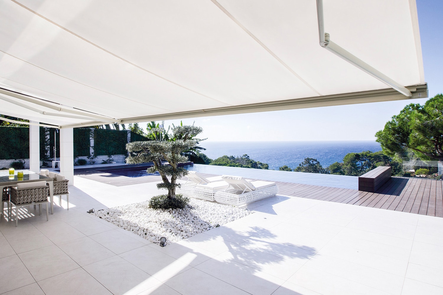 photo d'ambiance d'une terrasse lumineuse avec vue sur mer équipée de bannes solaires bandalux