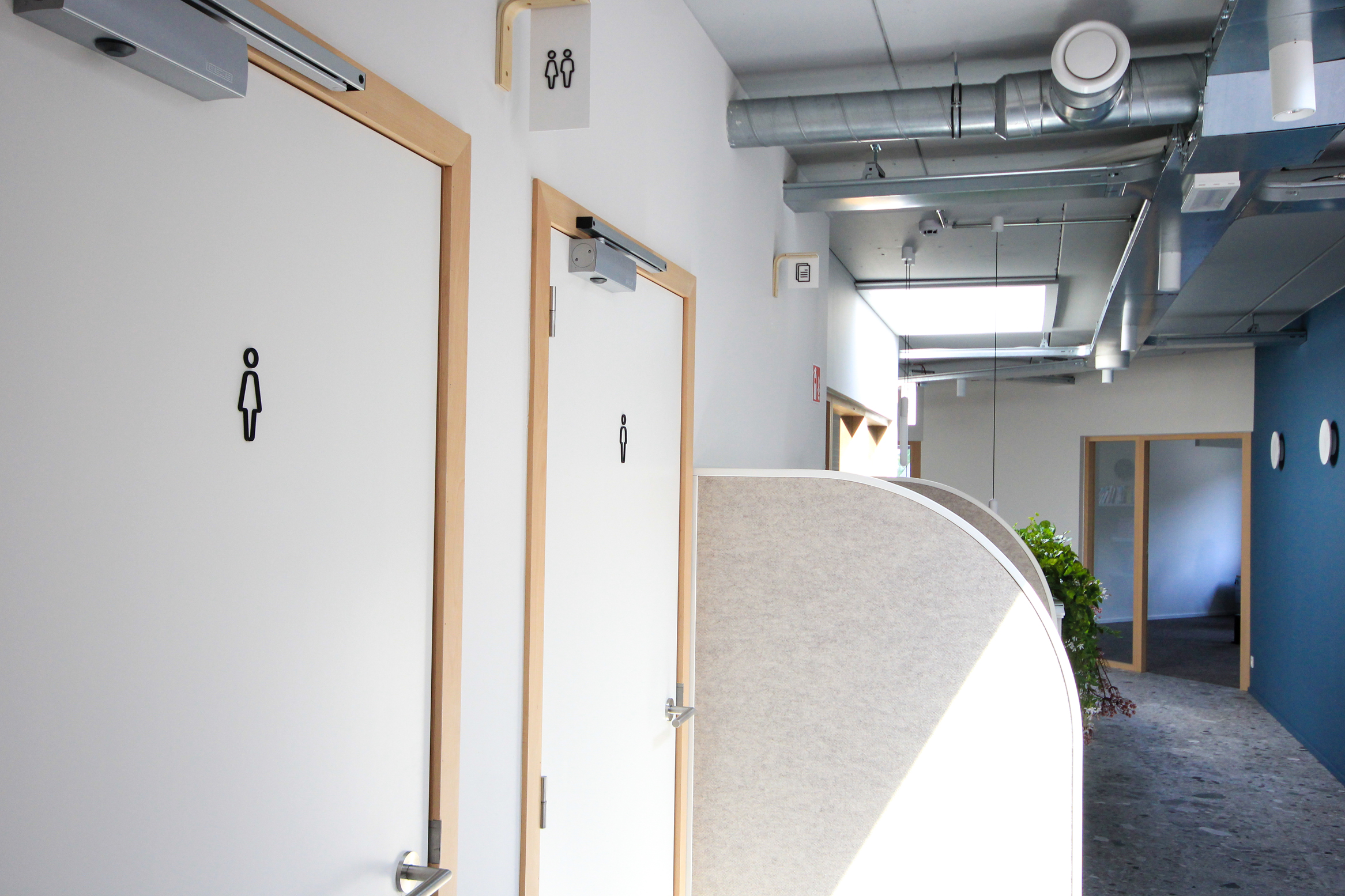 couloir du premier étage du Hub ou on aperçois différents éléments de signalétique réalisés par paper duck comme un numéro d'étage ou un drapeau indiquant une salle de réunion