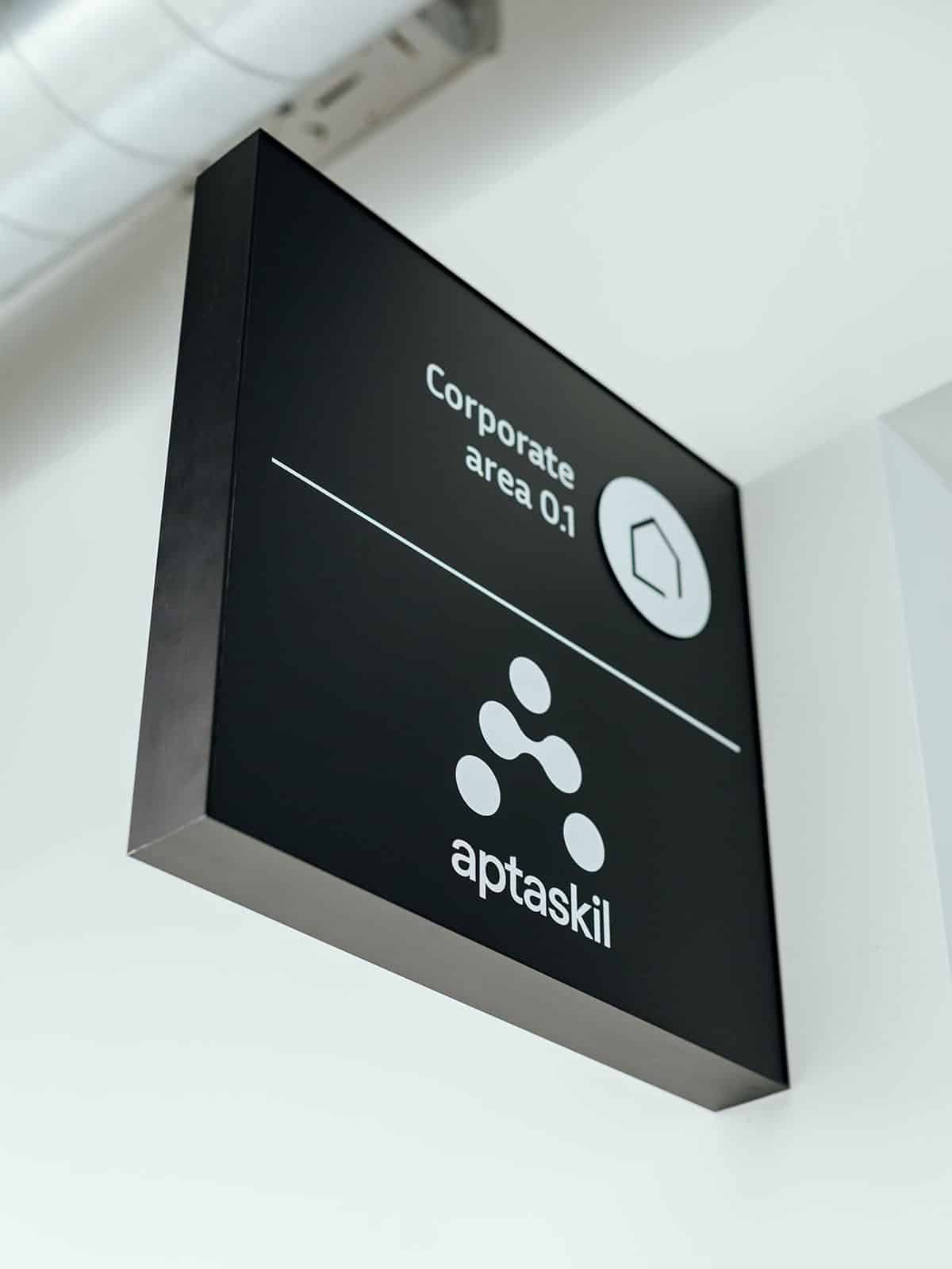 Zoom sur une box entreprise: box en aluminium noir reprenant le nom de la zone et le logo de l'entreprise qui la loue