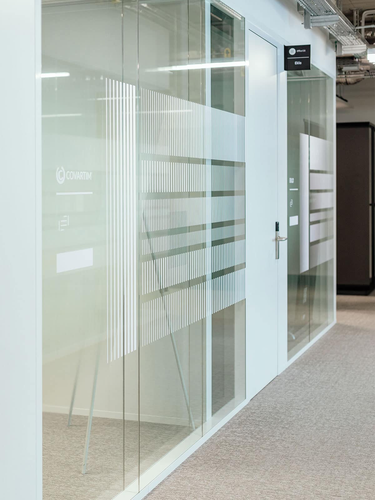 Deux bureaux d'un Private desk: avec l'habillage graphique sur les vitres imaginé pour donner de l'intimité aux locataires tout en apportant une touche graphique qui reflète l'esprit linéaire, sobre et géométrique du bâtiment