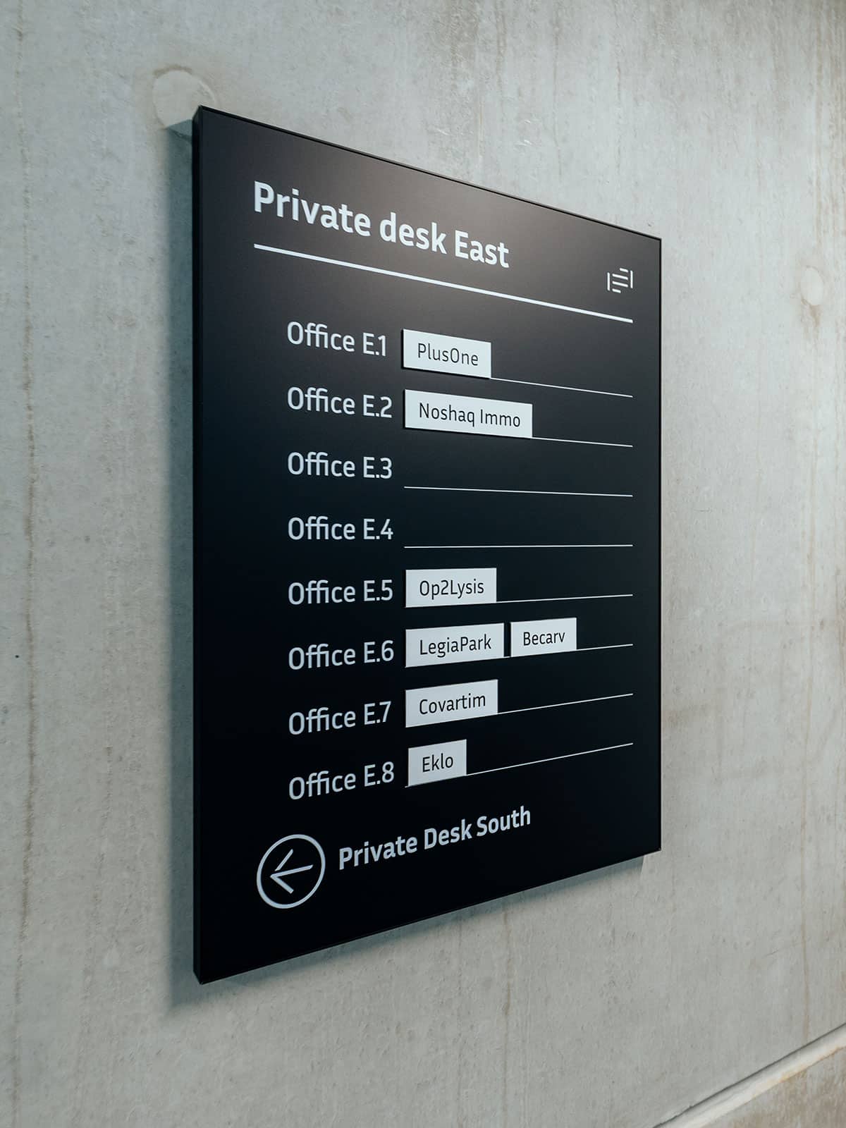 Zoom sur un répertoire général des entreprise, présent à l'entrée des Private desk, cette box noir est magnétique et des lagnets ont été créé sur mesure pour chaque entreprise pour pouvoir identifier qui se trouve dans quel espace et de pouvoir facilement adapter en cas de changement